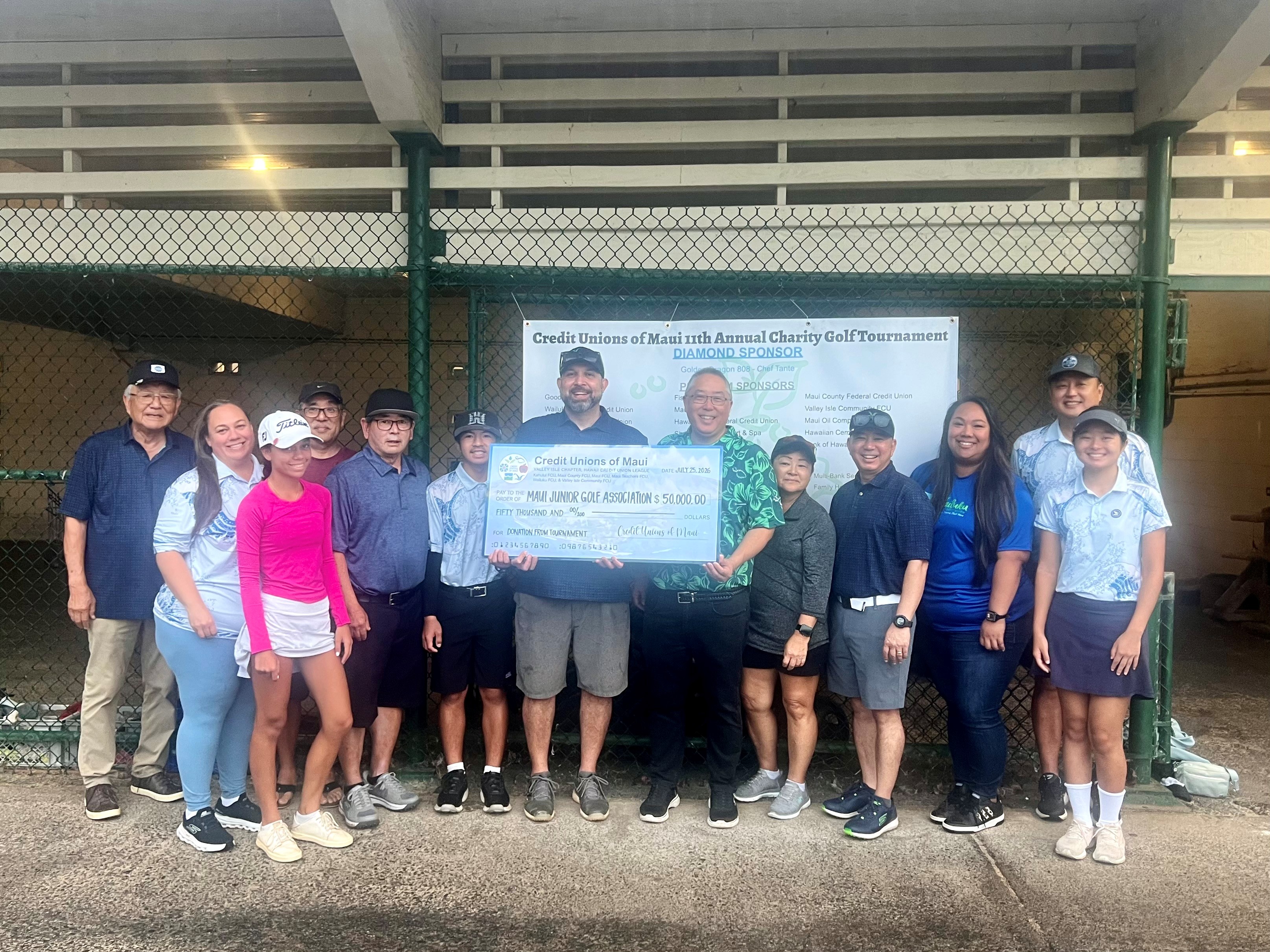 People holding Credit Unions of Maui check.
