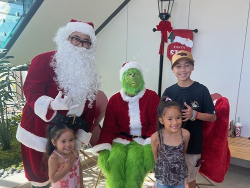 Santa and grinch with children.